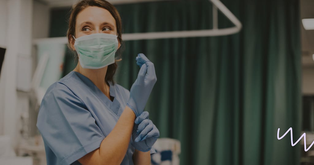 Nurse wearing a mask and putting on her glove in a nurse certification course