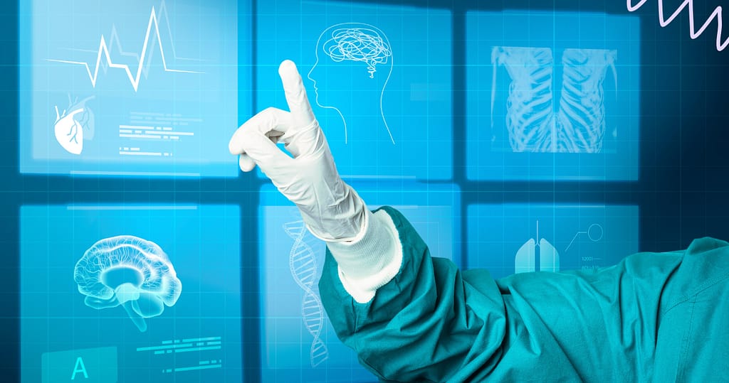 A hand in gloves pointing to a technology dense computer screen. The person is wearing scrubs, to represent AI tools for nurses