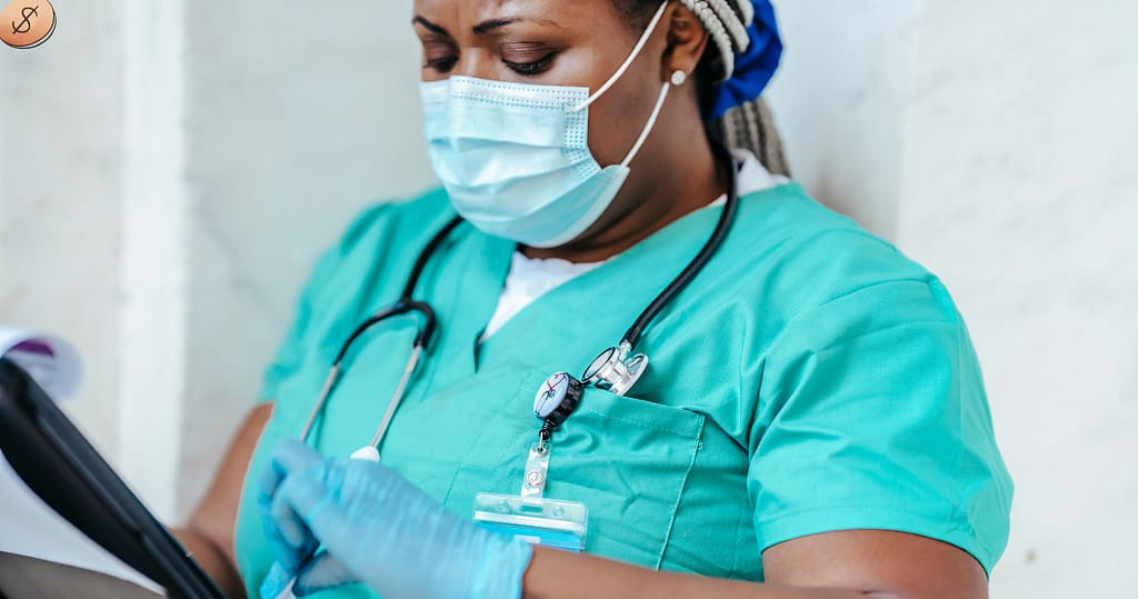 nurse wearing a mask reading about student loan debt for nurses