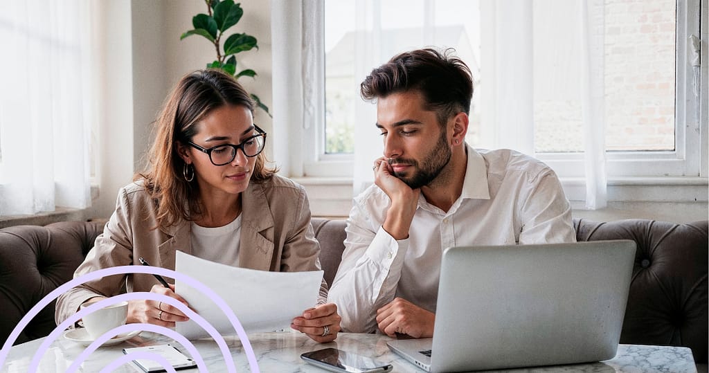 Couple reviewing financial documents at home with a laptop, planning for loan disbursement and repayment.