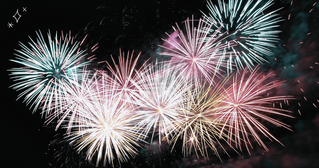 A vibrant display of colorful fireworks against a dark night sky, symbolizing celebration and new beginnings for financial wellness routines.